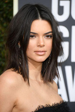Kendall Jenner stands out in the crowd with a rich black color and center part contrast.: 