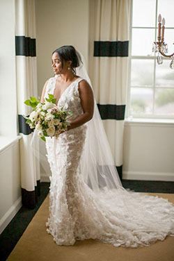 Bride stunned in a Marchesa feathered gown and long veil.: 