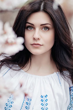 woman standing near white petaled flower: 