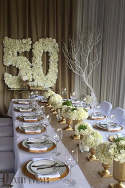 It's a golden dinner theme for the 50th, with white flowers and gold everywhere: 