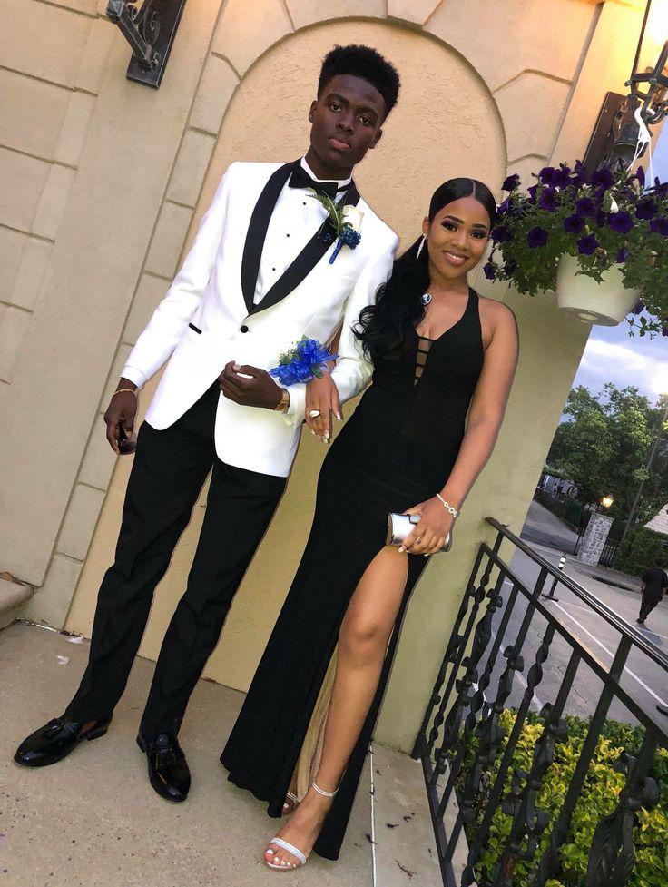 She's stunning in her sleek black gown with a daring slit, paired perfectly with his crisp white tuxedo jacket and black trousers!: Sheath dress,  Black Couple Homecoming Dresses  