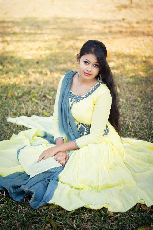 Selective Focus Photography of Woman Sitting on Green Grass: 