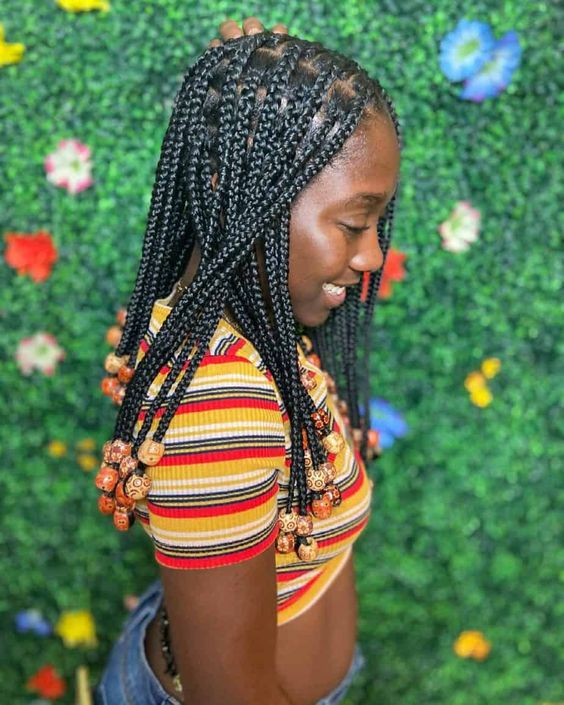 Those jet black knotless strands are channeling some serious bohemian vibes with that bead bliss: knotless braids with beads,  medium knotless braids,  knotless box braids,  facial expression,  box braids large,  small box braids,  Box braids  