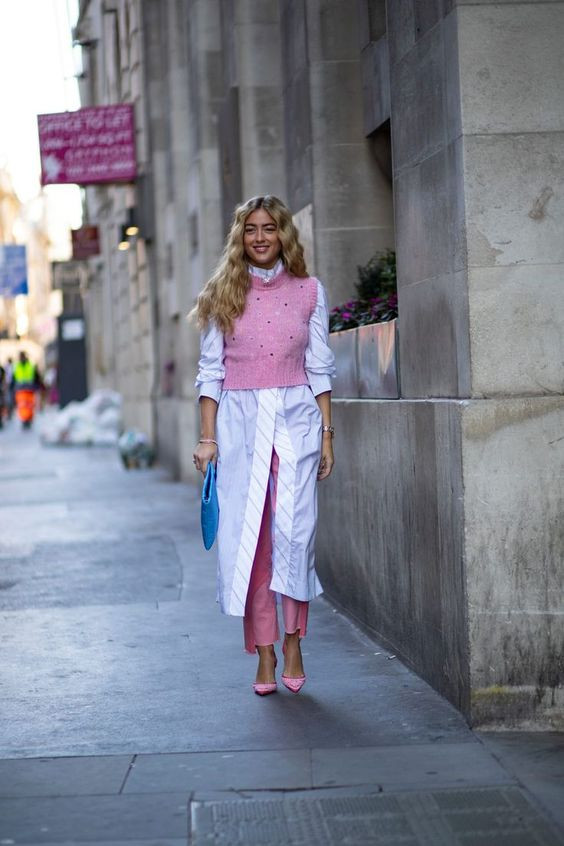 Combining striped affair with pink flair for a sweater vest look that's both bold and sophisticated: 